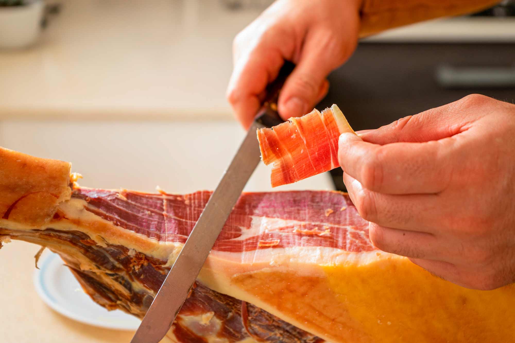 Persona cortando lonchas de jam&oacute;n ib&eacute;rico